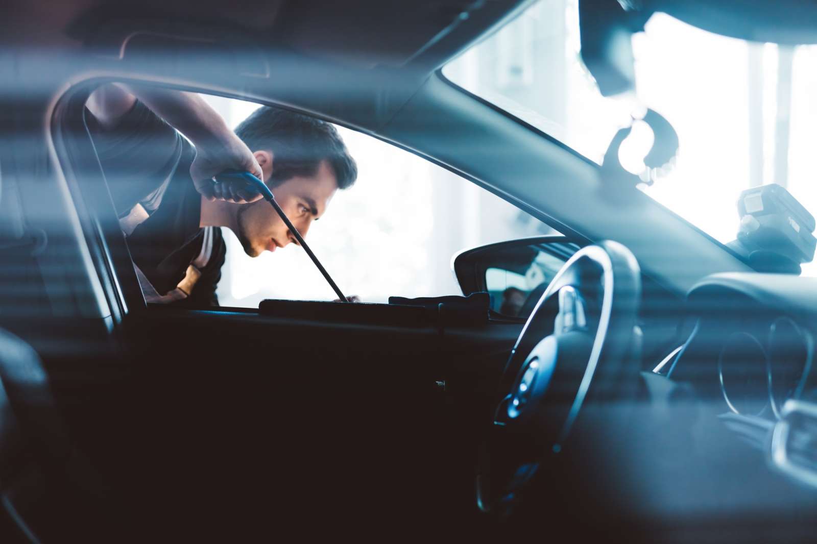 Car mechanic working to remove dent in workshop.